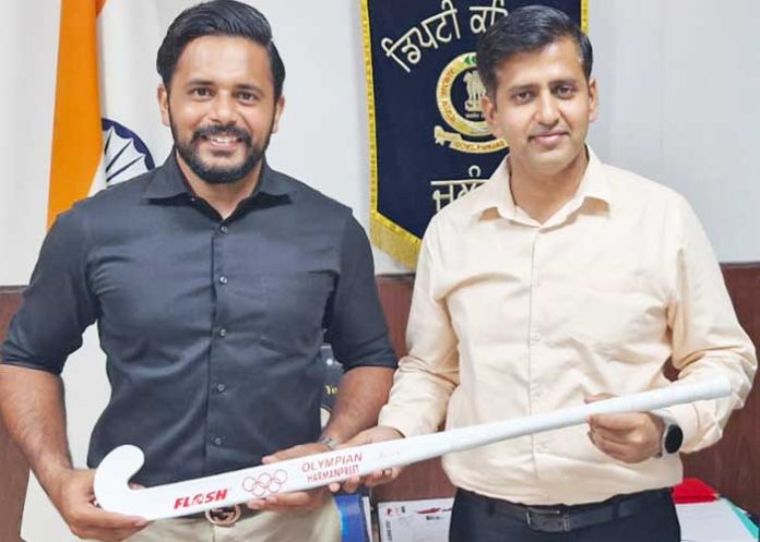 Hockey Captain Harmanpreet Singh hands over signed Hockey Stick to DC Dr. Himanshu Aggarwal